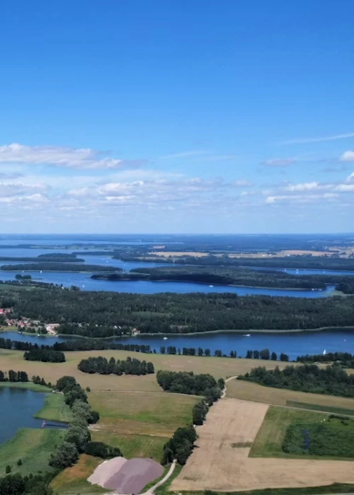 Widok z&nbsp;lotu ptaka na&nbsp;jeziora i&nbsp;lasy na&nbsp;Mazurach – luksusowe domki do&nbsp;wynajęcia
